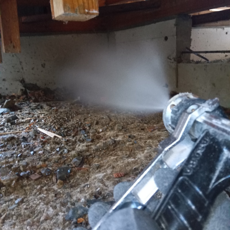 床下の基礎部分にシロアリ駆除剤を散布する様子