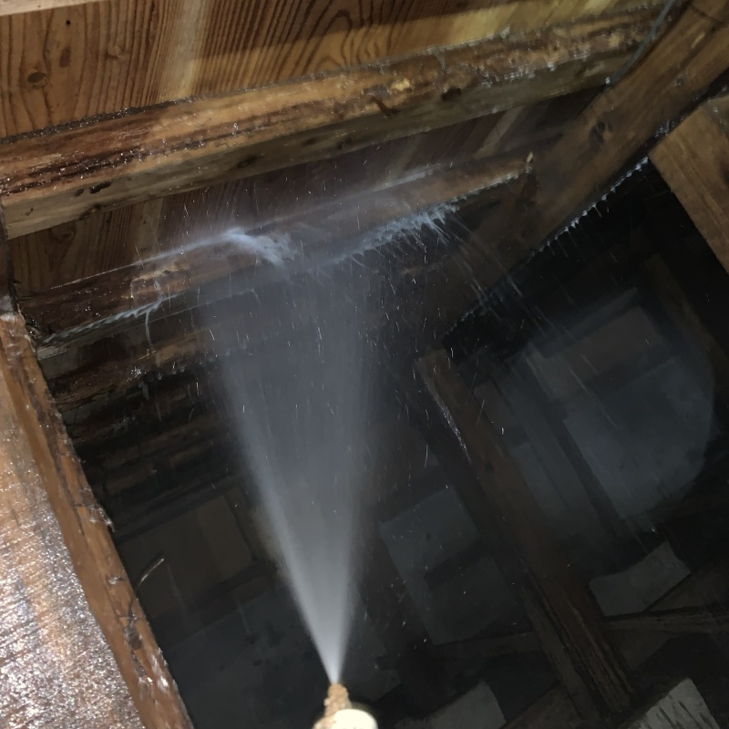 床下の木材にシロアリ駆除剤を散布する様子