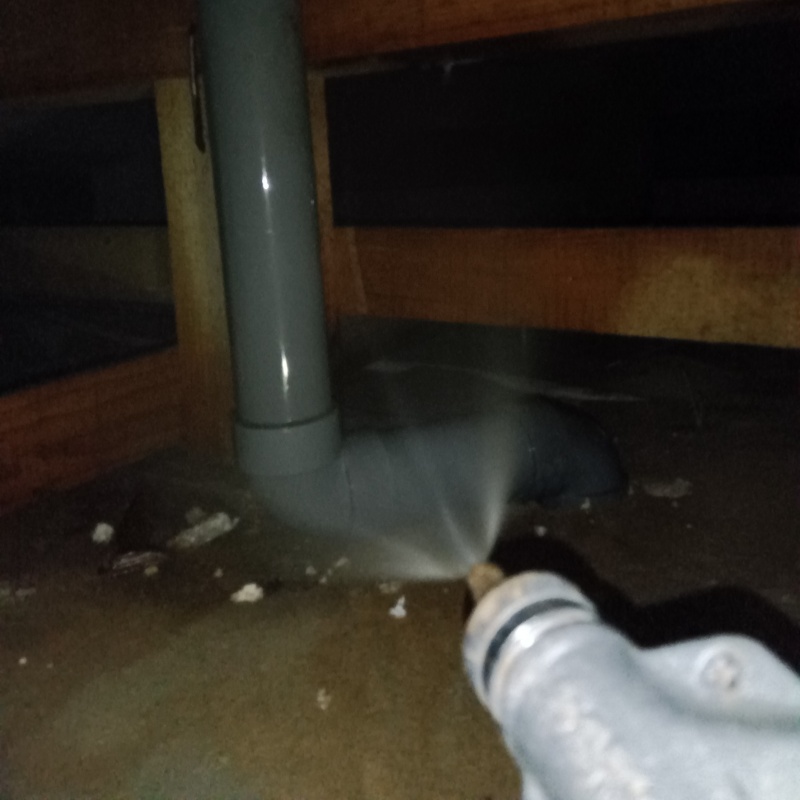 床下の土壌にシロアリ駆除剤を散布する様子