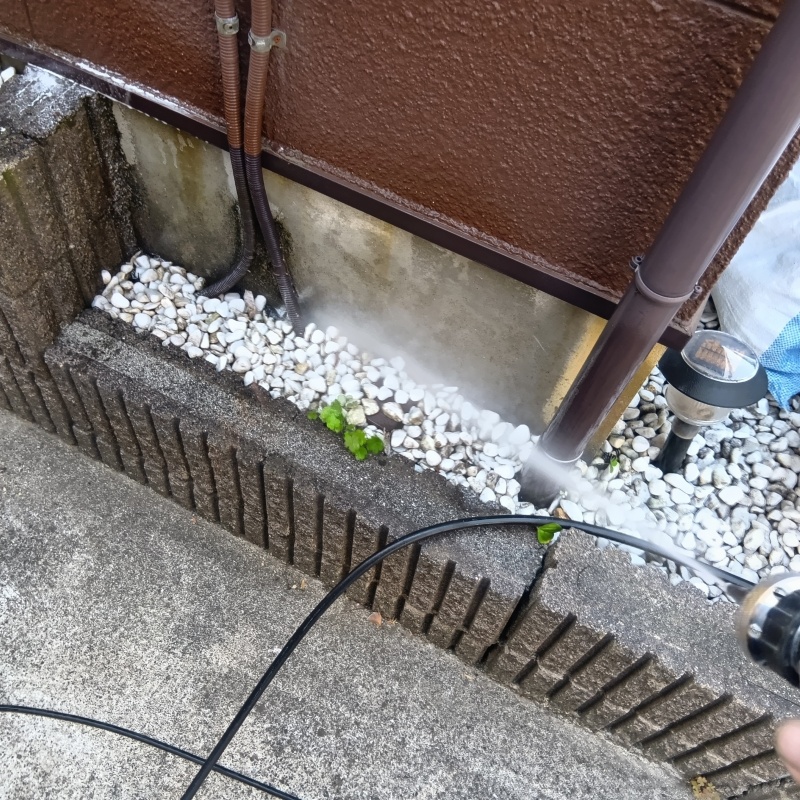 基礎まわりにシロアリ駆除剤を散布する様子