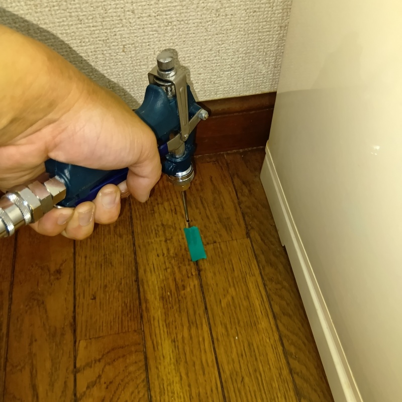 キッチンの床にシロアリ駆除剤を注入する様子