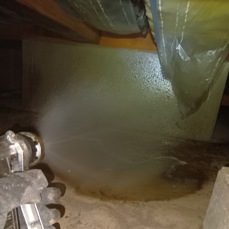 床下の基礎部分にシロアリ駆除剤を散布する様子