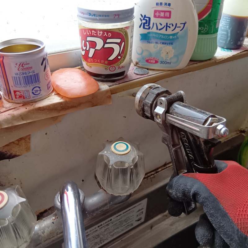 キッチンの壁にシロアリ駆除剤を注入する様子