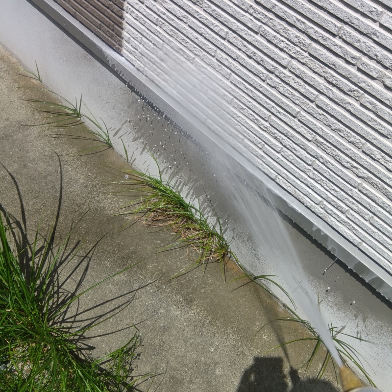 基礎まわりにシロアリ駆除を散布する様子