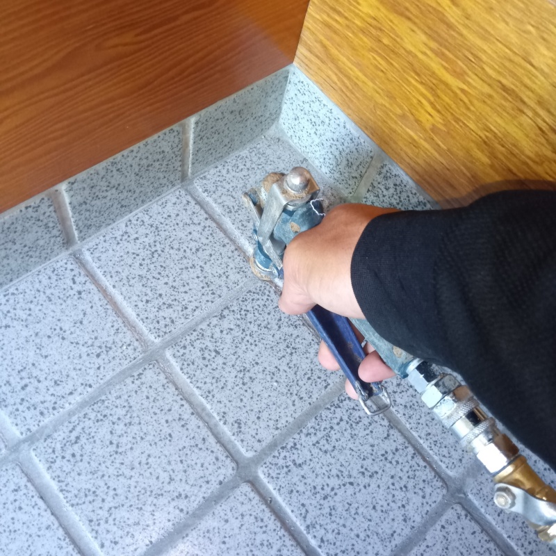 玄関の床にシロアリ駆除を注入する様子