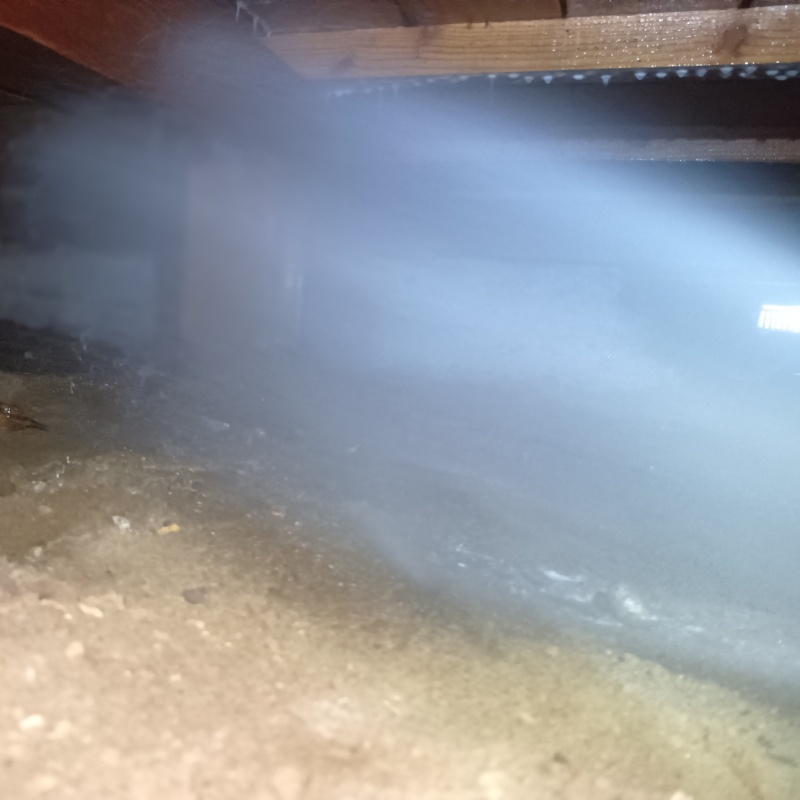 床下の土壌にシロアリ駆除剤を散布する様子