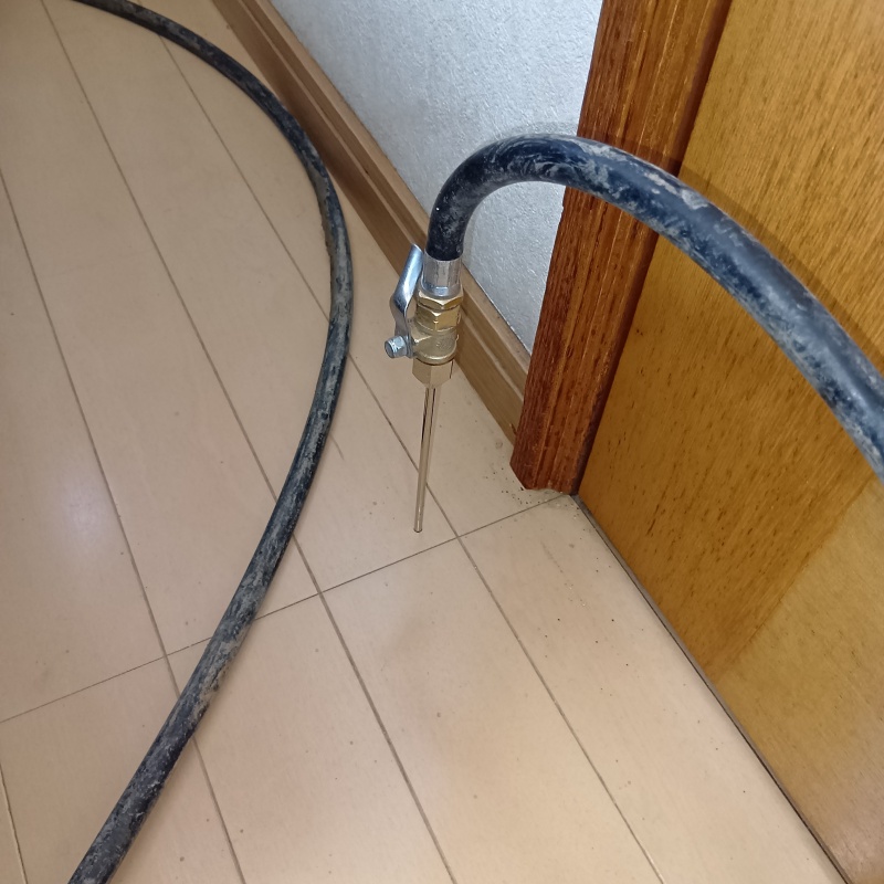 トイレ付近の床にシロアリ駆除を注入する様子