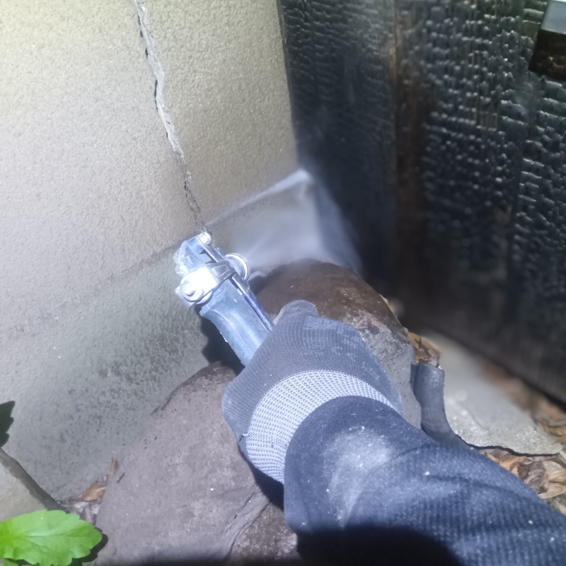 基礎まわりにシロアリ駆除剤を散布する様子