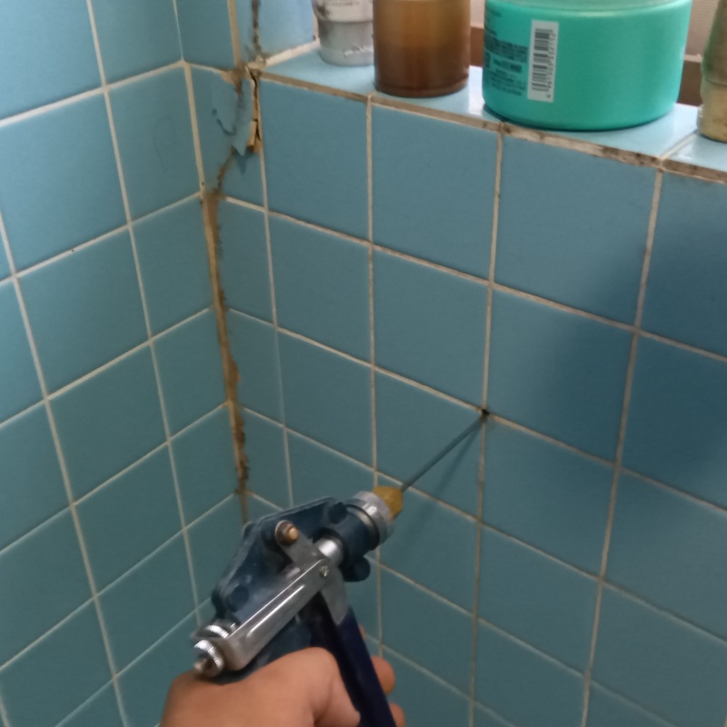 浴室の壁にシロアリ駆除剤を注入する様子