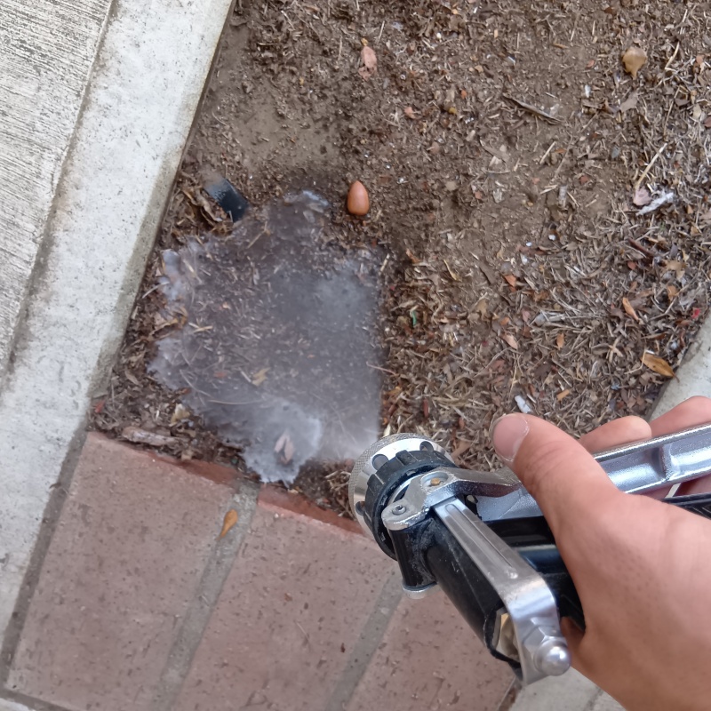 家まわりの土壌にシロアリ駆除剤を散布する様子