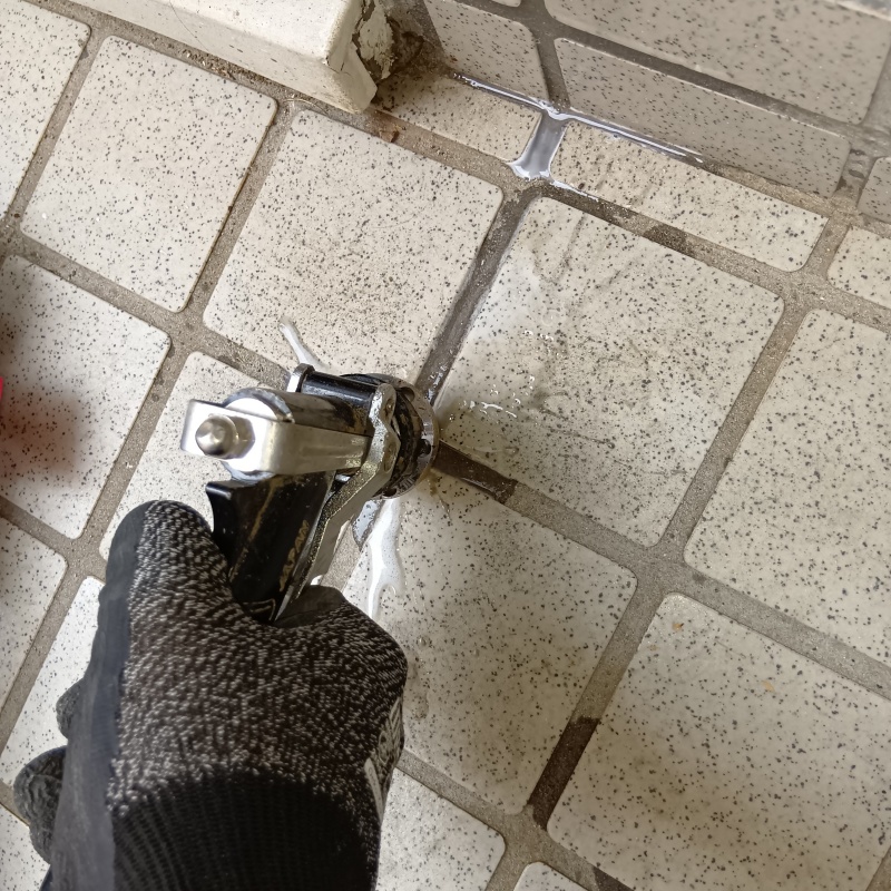 玄関の床にシロアリ駆除剤を注入する様子