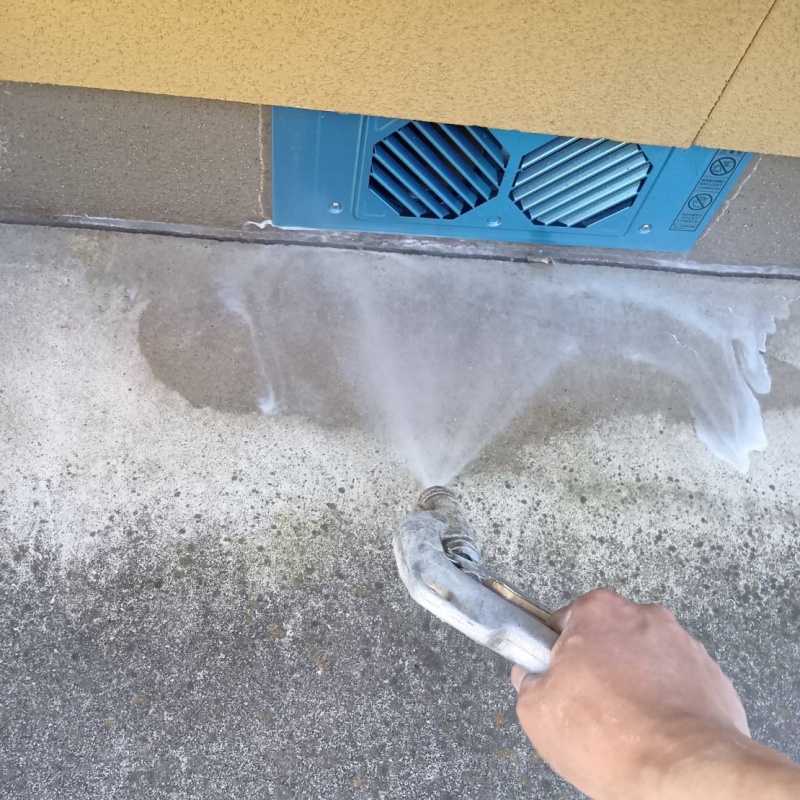 基礎まわりにシロアリ駆除剤を散布する様子