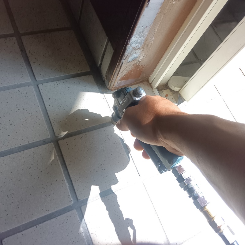玄関の床にシロアリ駆除を注入する様子