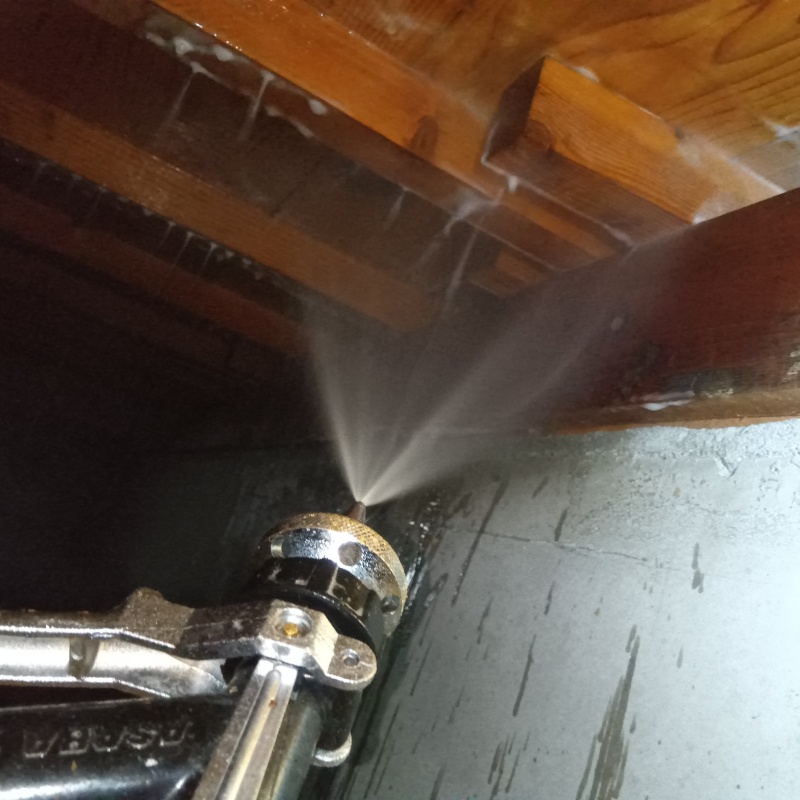 床下の木材にシロアリ駆除剤を散布する様子