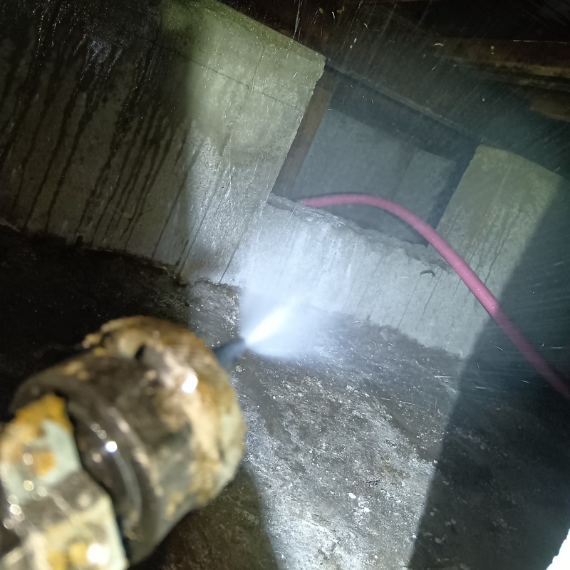 床下の土壌にシロアリ駆除剤を散布する様子