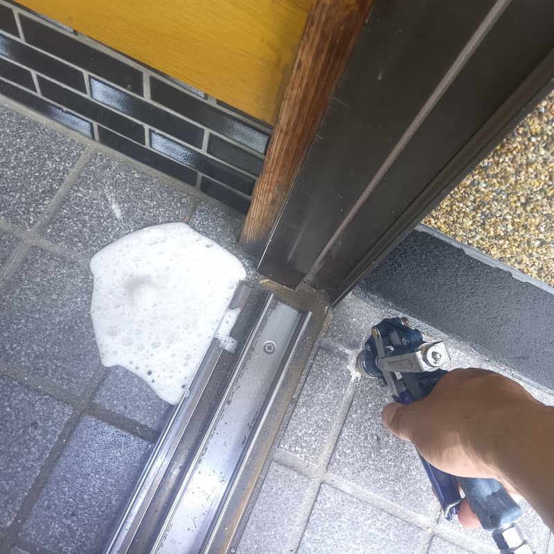 玄関の床にシロアリ駆除剤を注入する様子