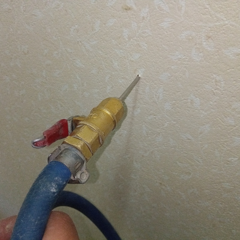 トイレの壁にシロアリ駆除剤を注入する様子
