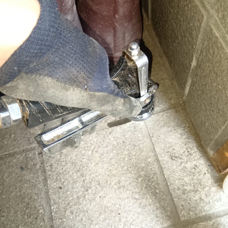 玄関の床にシロアリ駆除剤を注入する様子