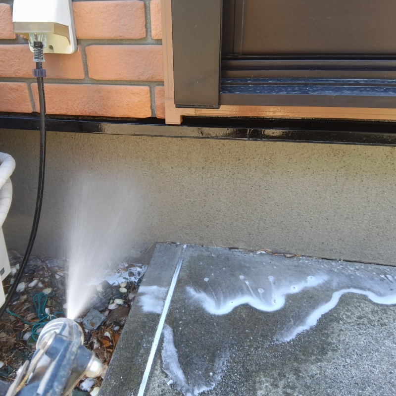 基礎まわりににシロアリ駆除剤を散布する様子