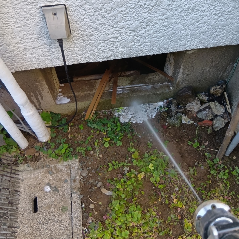 基礎まわりにシロアリ駆除剤を散布する様子