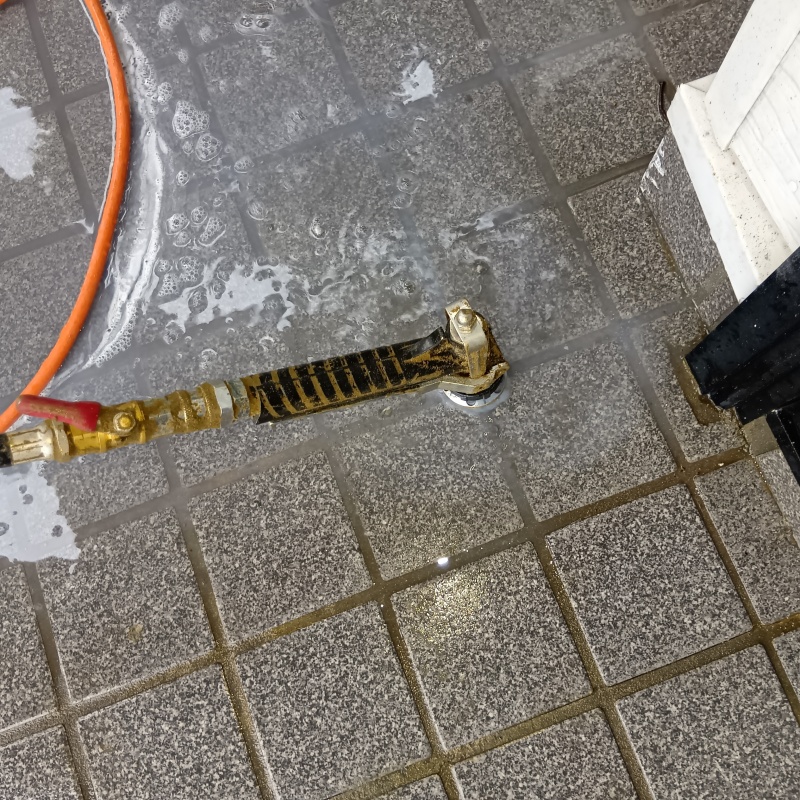 玄関の床にシロアリ駆除剤を注入する様子