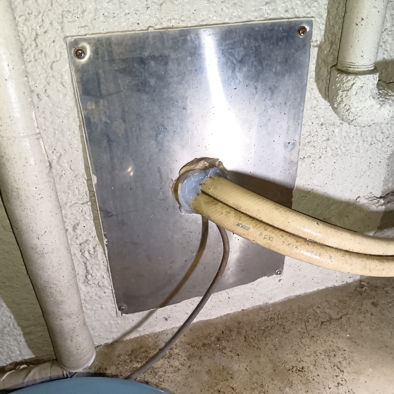 排水ホースの導入部分をパテで封鎖