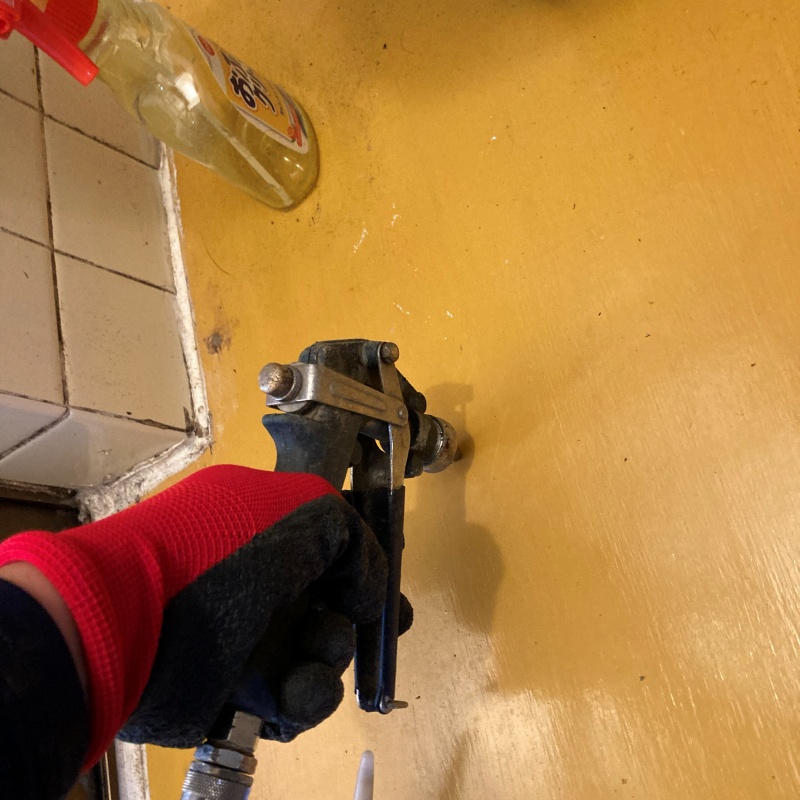 トイレの床にシロアリ駆除剤を注入する様子