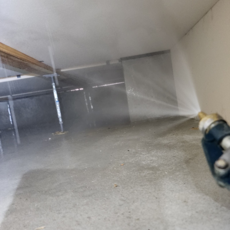 床下の基礎部分にシロアリ駆除剤を散布する様子