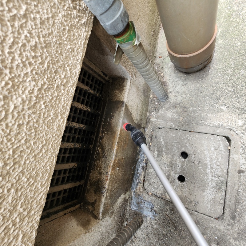 基礎まわりにシロアリ駆除剤を散布する様子