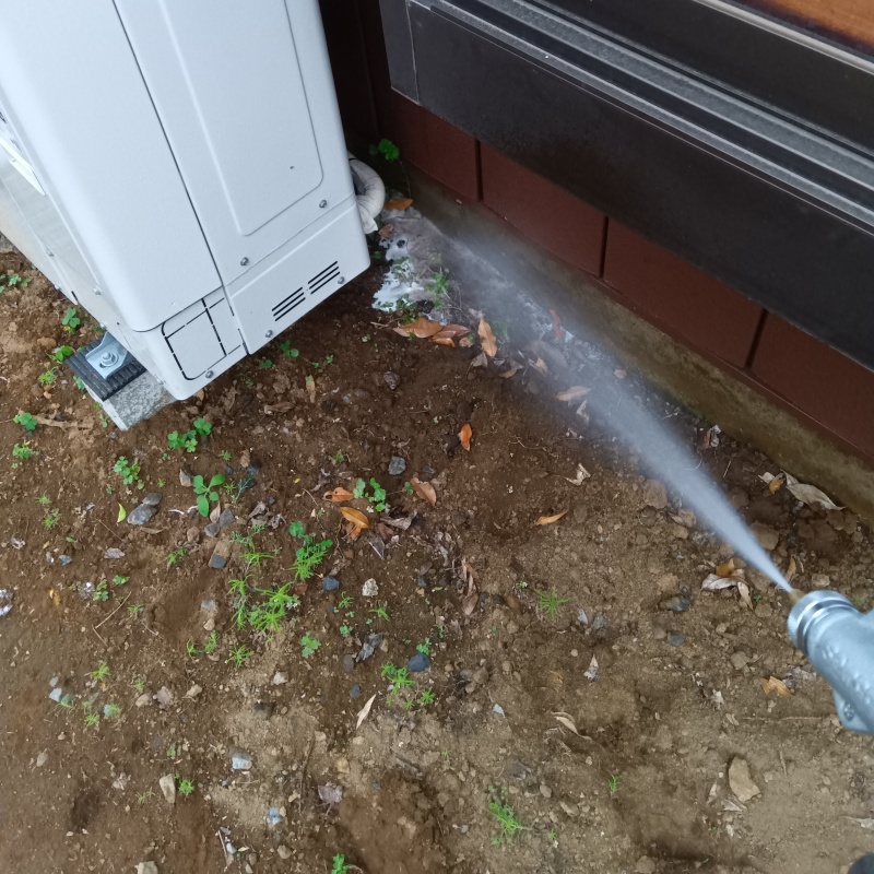 基礎まわりにシロアリ駆除剤を散布する様子
