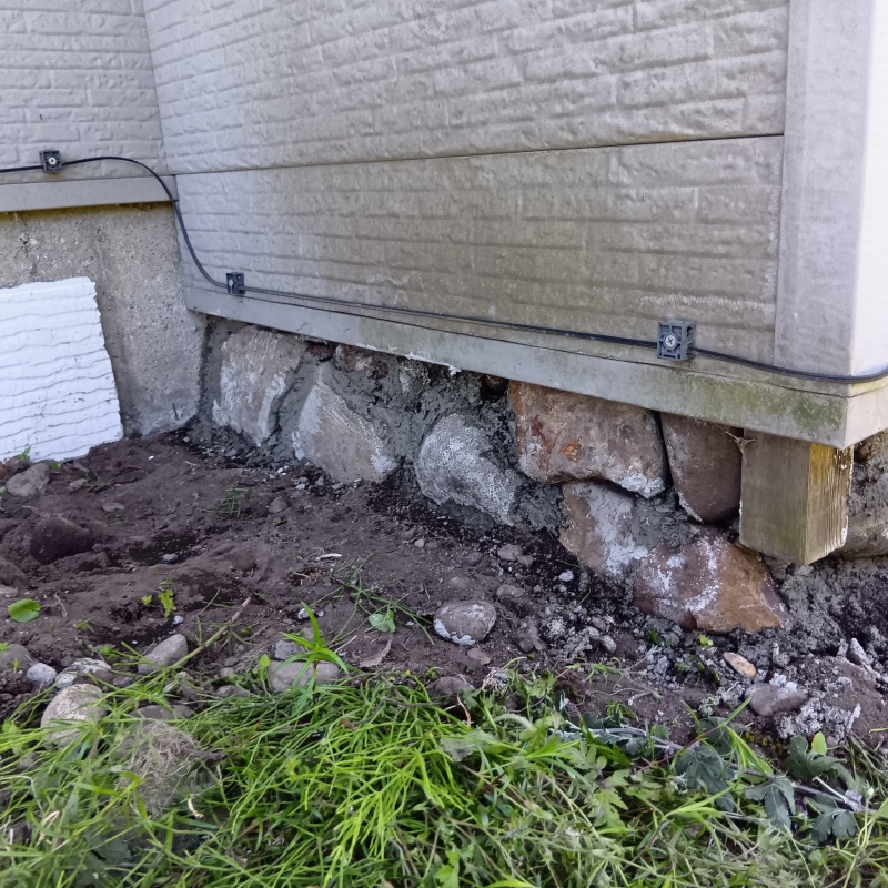 建物と地面の間のすき間を石で封鎖
