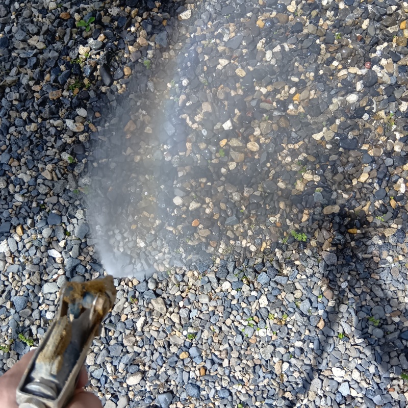 玄関先の土壌にシロアリ駆除剤を散布