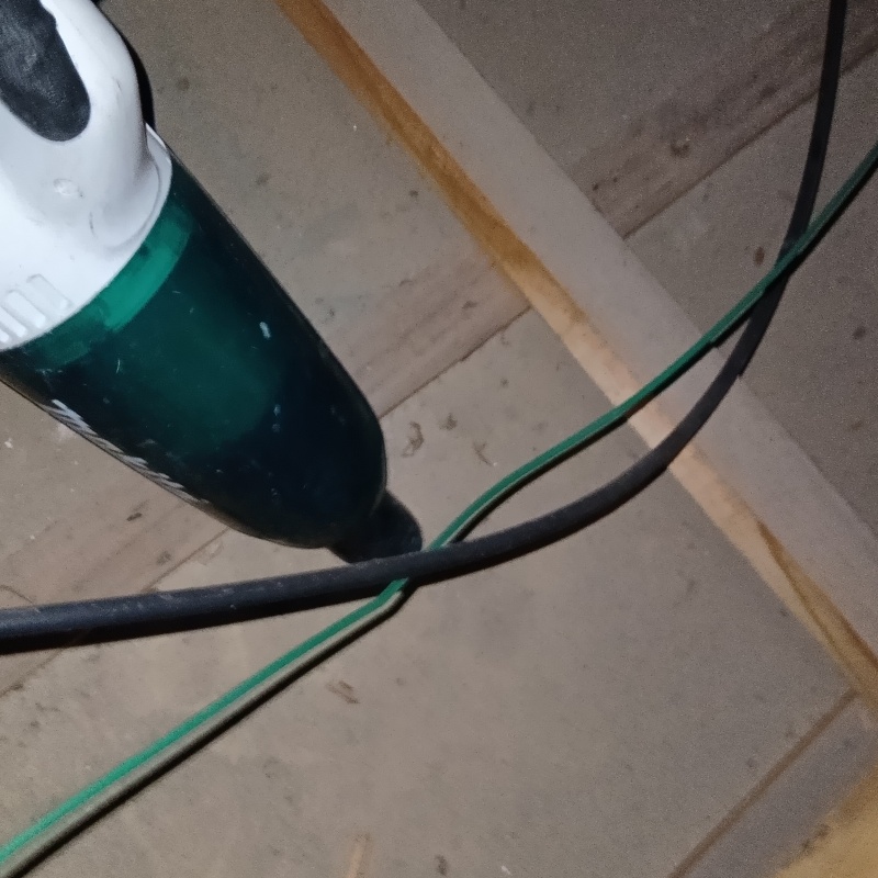 屋根裏を掃除機で清掃